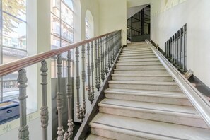 A marble staircase with ornate balusters, leading to a landing with a glass door. - GuestHost - Charming 85 sqm apartment, ideal for groups or families of up to 5 guests, located on the third floor of a historic building with an elevator (NOT suitable for guests with disabilities).The property is located in an elegant area, right in the (Turin)