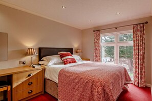 A bedroom with a bed, bedside lamps, a wooden nightstand, a dresser, and a window with curtains. - 3 Bed in Two Waters Foot (oc-m27335) (Broadoak)