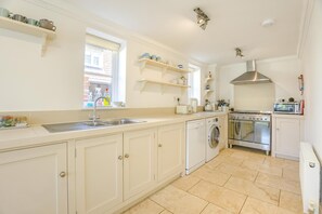 A modern kitchen with a sink, washing machine, oven, and microwave. - 4 Bed in Friston (oc-colu) (Friston)