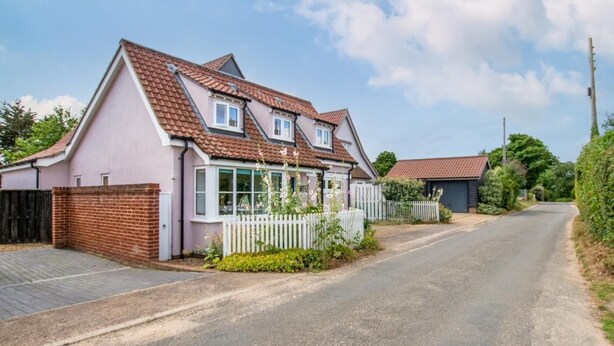 A single-story house with a red-tiled roof, a white picket fence, and a small garden with flowers. - 4 Bed in Friston (oc-colu) (Friston)