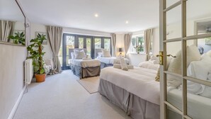 A hotel room with two beds, a potted plant, a radiator, and a view of the outdoors. - 6 Bed in Foulsham (oc-t33038) (Foulsham)