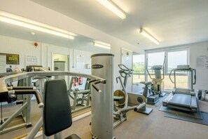 A gym with various exercise equipment, a mirrored wall, and a large window. - 2 Bed in Blythburgh (oc-wag2) (Bulcamp)