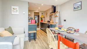 Un espacio habitable compacto con kitchenette, comedor y sofá.
