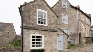 A stone building with multiple windows and a door, featuring a traditional architectural style. - 2 Bed in Swanage (oc-wy501) (Swanage)
