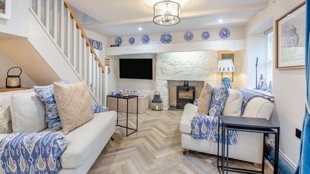 Una sala de estar con chimenea, televisor y escalera.
