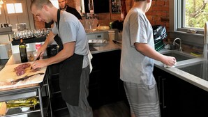Una cucina con pareti in mattoni, lampadine a sospensione e una finestra vista alberi.