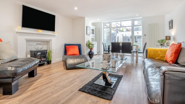 A modern living room with leather sofas, a glass coffee table, and a fireplace. - 3 Bed in Sandsend (oc-a33016) (Sandsend)