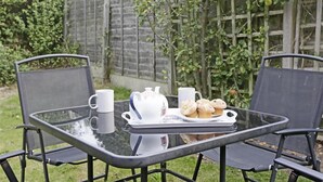 A glass table with two chairs, a tray with a teapot, cups, and muffins. - 2 Bed in Walberswick (oc-grs) (Walberswick)