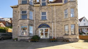 A stone building with a prominent entrance, multiple windows, and a sign that reads "Marine Aquarium."