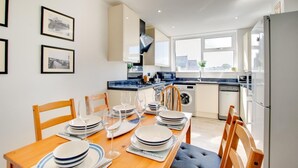A modern kitchen with a dining area set for six.