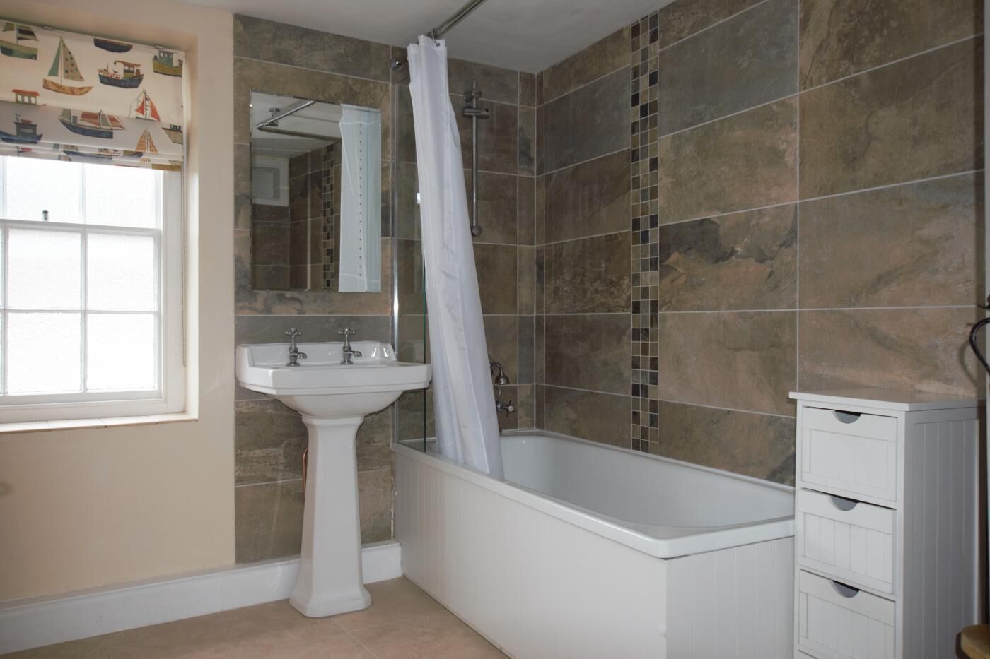 A bathroom with a bathtub, a sink, and a shower curtain.