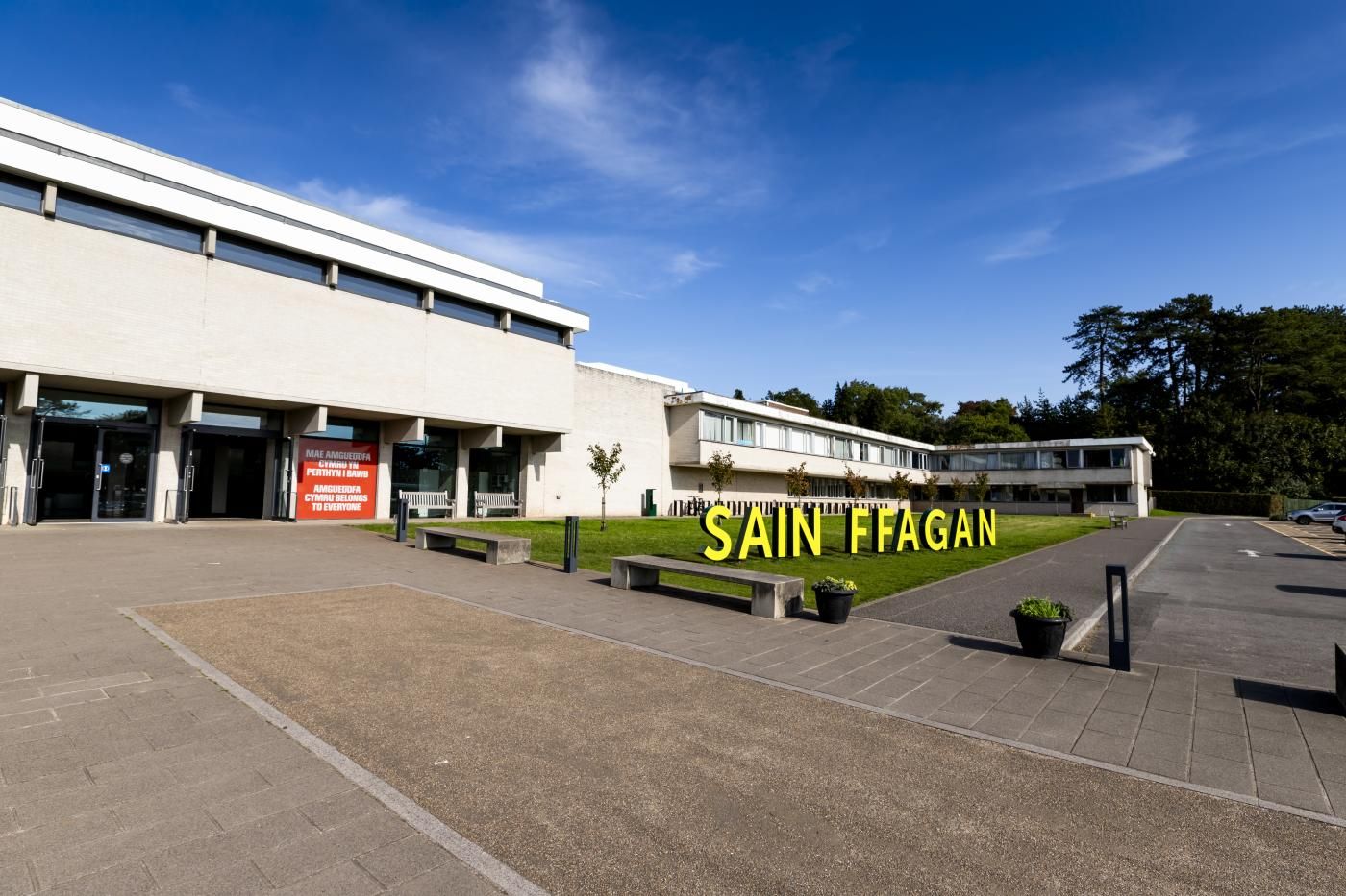 A building with a sign reading 'SAIN FFAGAN' and a parking lot.