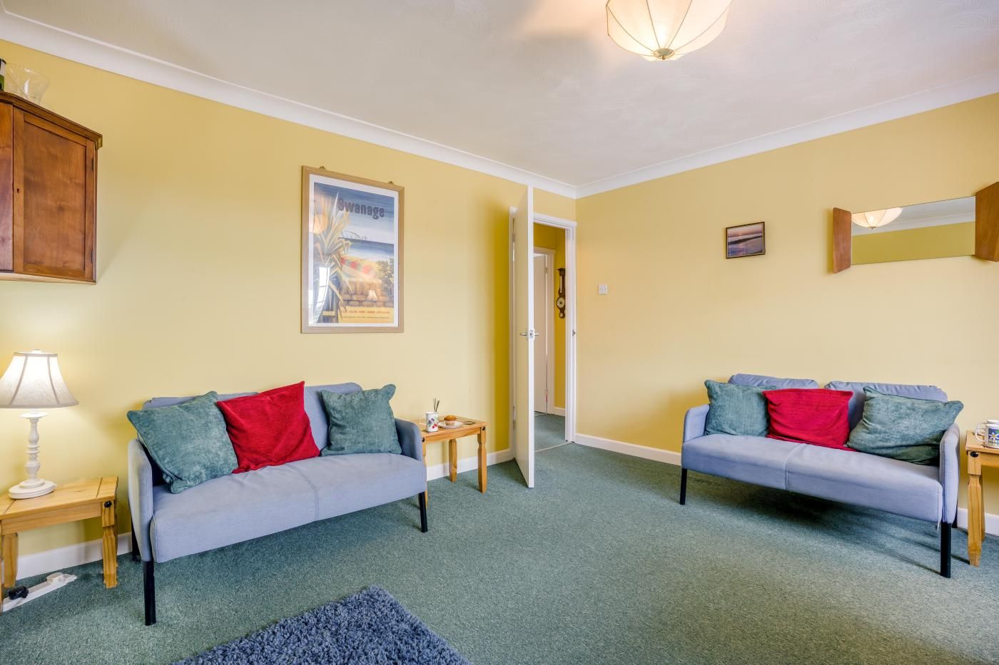 A living room with two sofas, a lamp, a framed picture, and a small table.