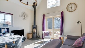 Una sala acogedora con chimenea, comedor y sofá.