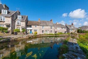Une rangée de bâtiments en pierre, avec un canal en premier plan.