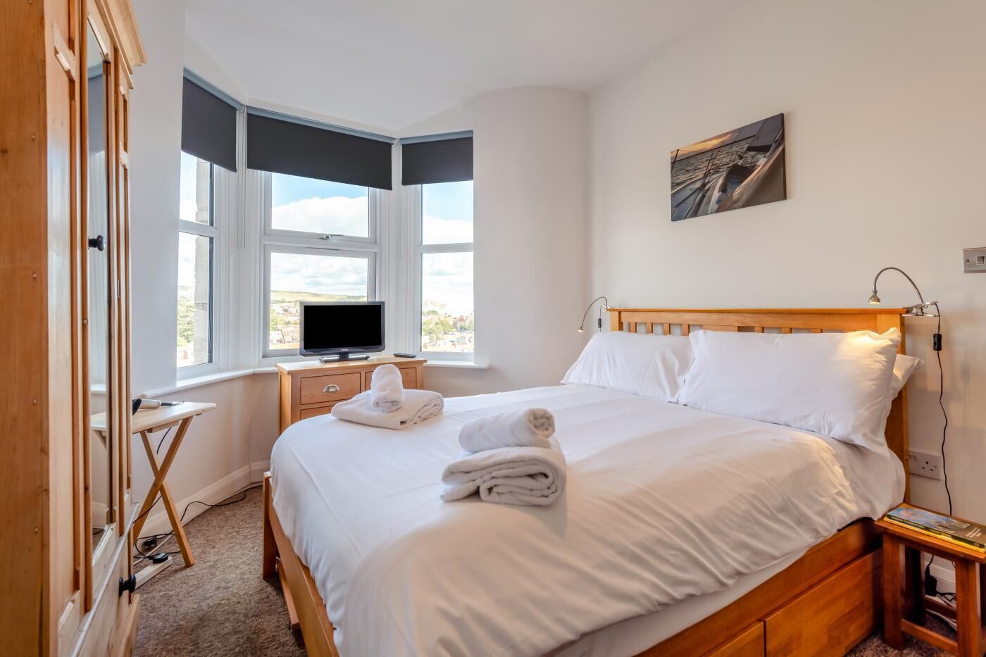 Ett hotellrum med en säng, en tv, ett skrivbord och ett fönster med utsikt.