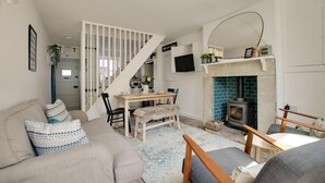 Una sala de estar acogedora con un sofá, una mesa de comedor y una chimenea.