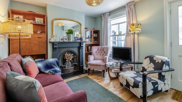 A cozy living room with a fireplace, a sofa, a chair, a television, and a bookshelf. - 2 Bed in Whitstable (oc-o32772) (Whitstable)