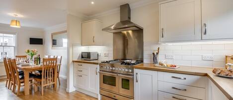 Ovn, oppvaskmaskin, høy barnestol og kjøkkenutstyr