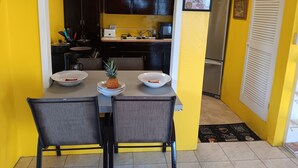 Cocina compacta con armarios oscuros, un microondas y un refrigerador.