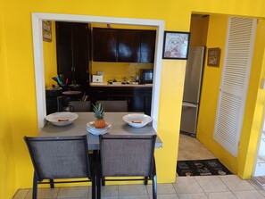 A compact kitchen with dark cabinets, a microwave, and a refrigerator.