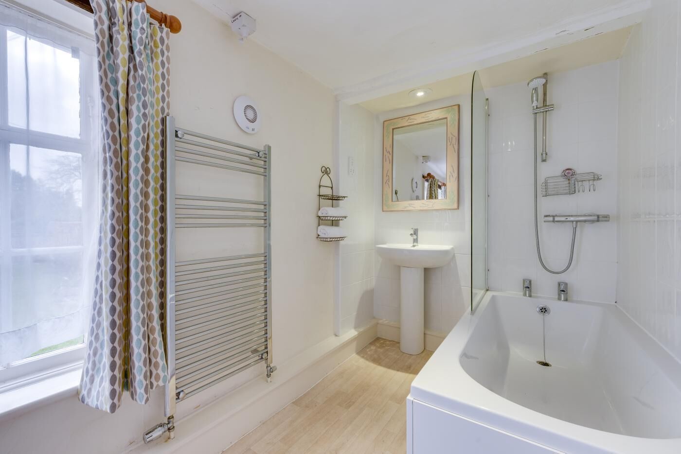 Ein modernes Badezimmer mit Badewanne, Waschbecken, Dusche und Handtuchhalter.