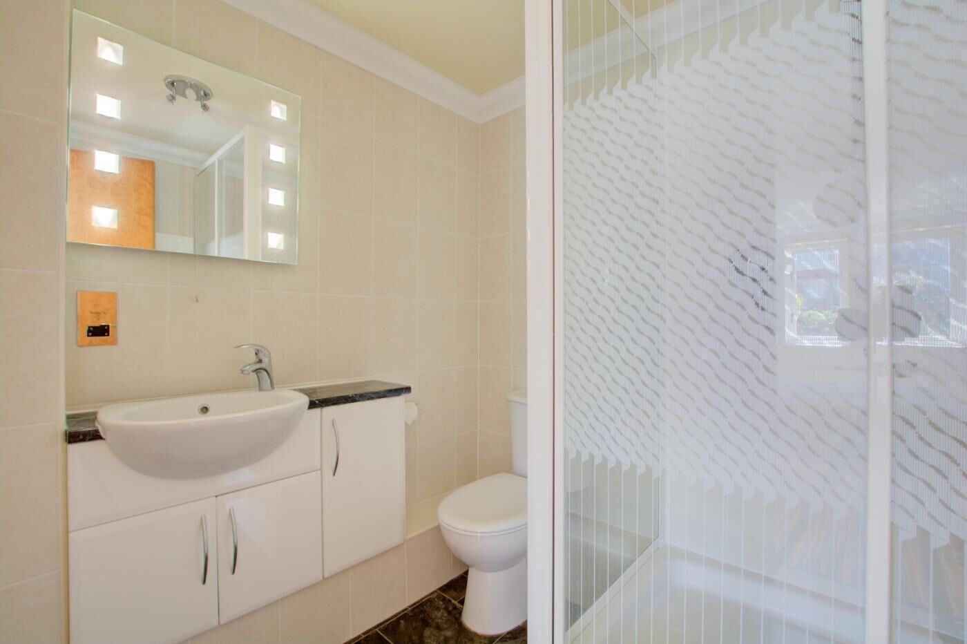 Un bany amb un lavabo blanc, un mirall i un vàter.