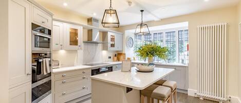 Een magnetron, een oven, een vaatwasser, kookgerei, borden en bestek