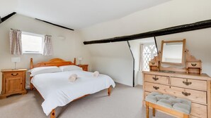 A bedroom with a wooden bed, a dresser, a mirror, and a window with curtains. - 4 Bed in Saxmundham (oc-oth) (Dunwich)