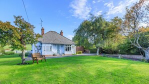 A single-story house with a sloped roof, a front porch, and a well-maintained lawn.