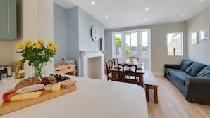 Eine moderne Küche mit Essbereich, Wohnzimmer und Kamin.