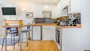 A compact kitchen with a wooden countertop, a built-in oven, and a microwave. - 1 Bed in West Bay (oc-wy537) (West Bay)