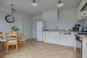 Een magnetron, een oven, een vaatwasser, kookgerei, borden en bestek