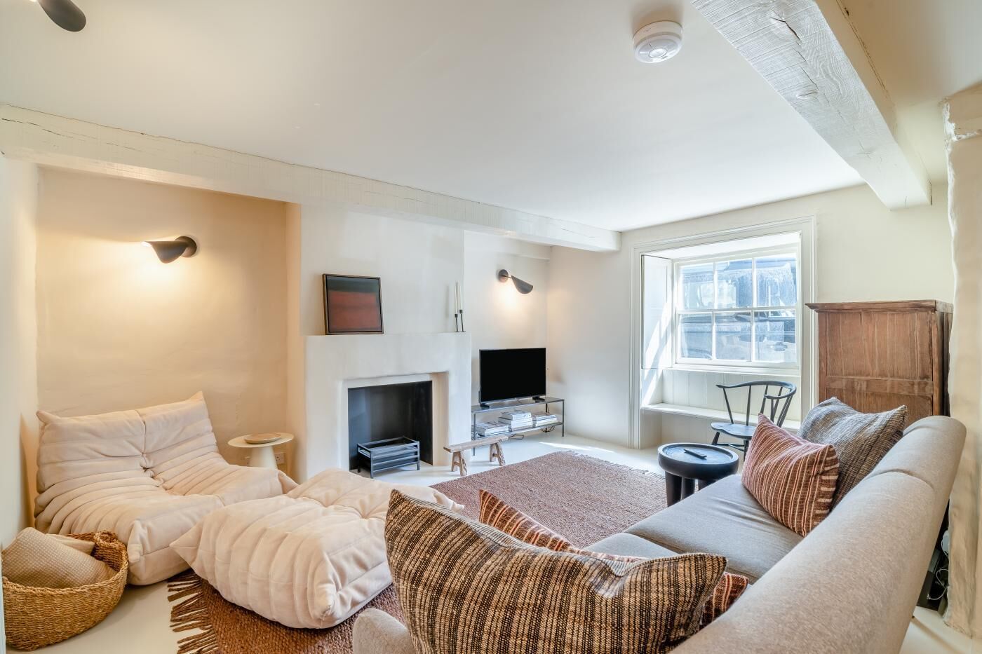 Ein Wohnzimmer mit Kamin, einer Couch, einem Fernseher und einem Fenster mit Aussicht.