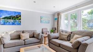 A living room with two sofas, a coffee table, and artwork on the walls. - 2 Bed in Swanage (oc-wy552) (Swanage)