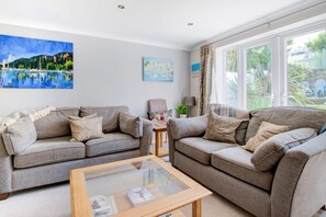 A living room with two sofas, a coffee table, and artwork on the walls. - 2 Bed in Swanage (oc-wy552) (Swanage)
