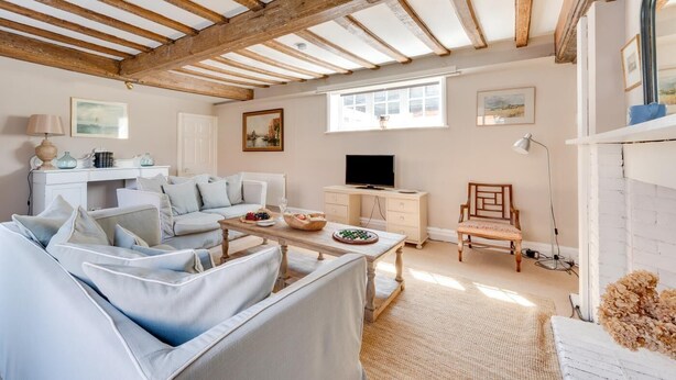 A cozy living room with a white sofa, a wooden coffee table, and a television. - 1 Bed in Southwold (oc-rest) (Southwold)