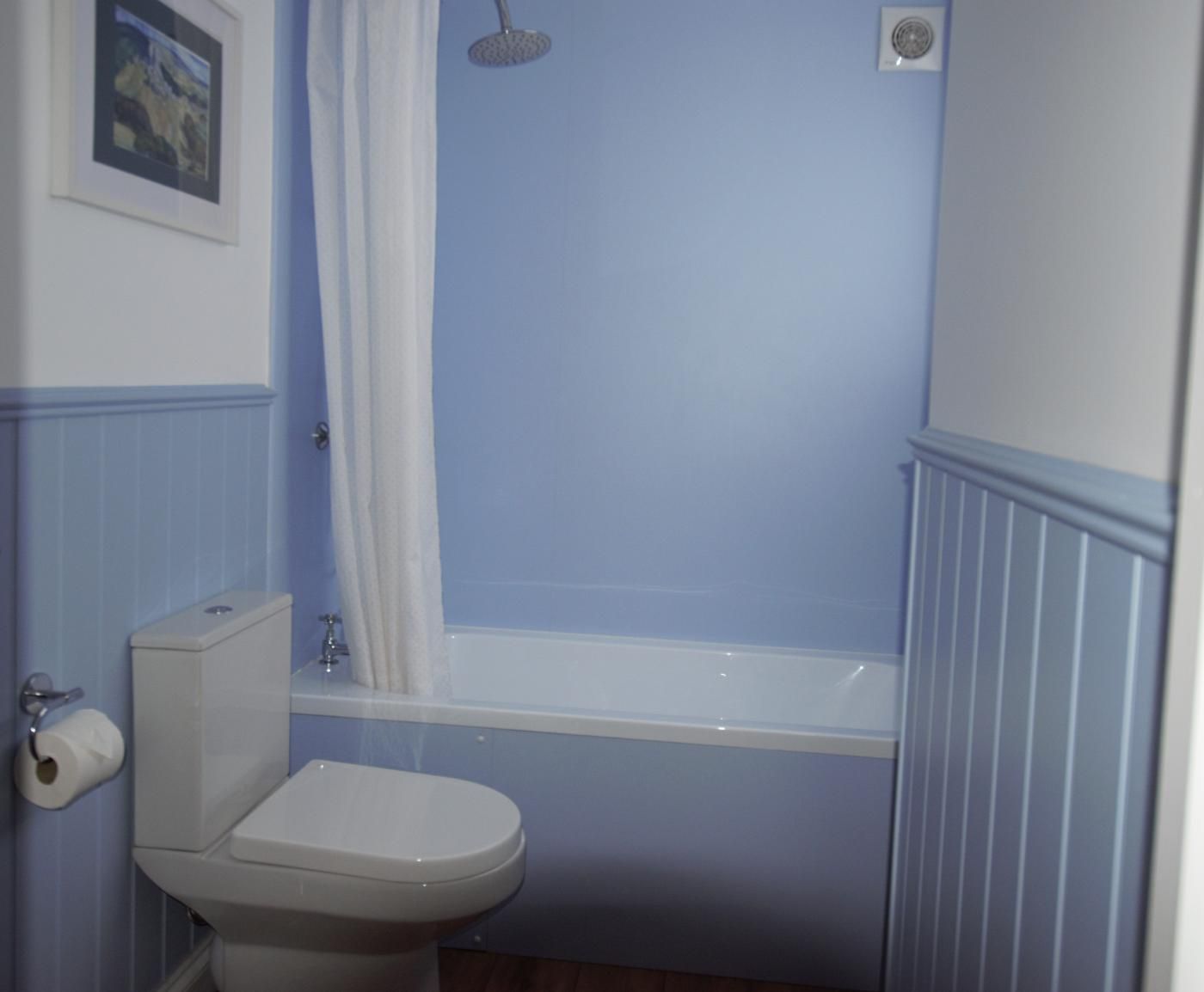 Een badkamer met een toilet, douche en bad.