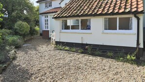 A two-story house with a gravel driveway and a garden. - 3 Bed in Leiston (oc-wil) (East Bridge)