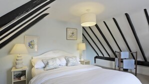 A bedroom with a bed, two bedside tables, a hanging light fixture, a framed picture, and a wooden beam structure on the ceiling. - 3 Bed in Leiston (oc-wil) (East Bridge)