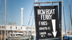 Schild für eine Fähre mit Ruderboot, mit aufgelisteten Preisen.