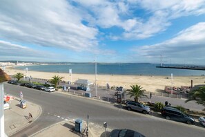 A coastal road with a beach, parked cars, and a clear sky. - 1 Bed in Weymouth (oc-wy435) (Weymouth)