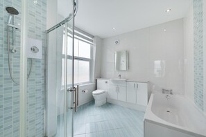 A modern bathroom with a glass shower enclosure, a white toilet, a sink with a mirror, and a bathtub. - 1 Bed in Weymouth (oc-wy435) (Weymouth)