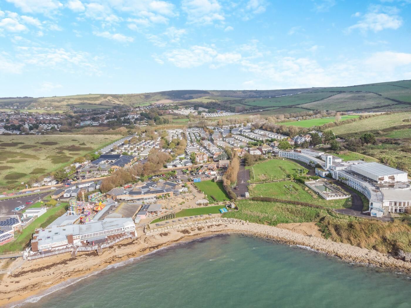 A coastal town with a marina, residential areas, and a large industrial building.