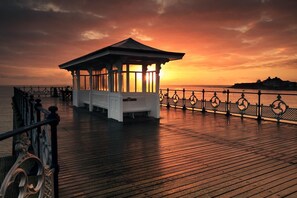 A wooden pier with a gazebo at sunset. - 2 Bed in Swanage (oc-wy527) (Swanage)