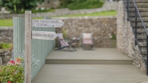 A wooden signpost with directions to 'The Coach House' and 'Askrigg' with distances marked. - 1 Bed in Askrigg (oc-c33109) (Askrigg)