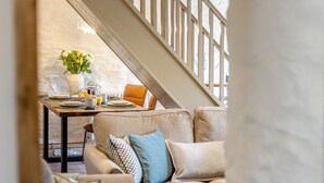 A dining area with a table set for two, a vase with flowers, and a staircase in the background. - 2 Bed in Cwmystwyth (oc-p32779) (Cwmystwyth)
