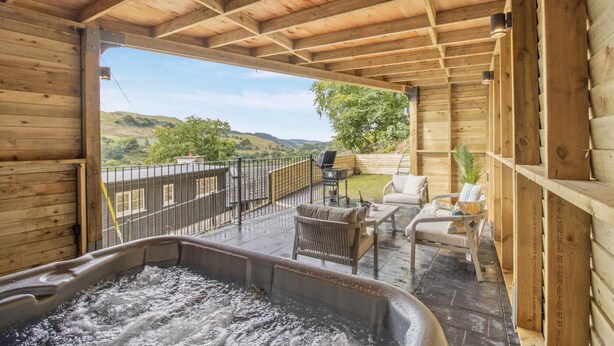 A wooden cabin with a hot tub, outdoor seating, and a view of the countryside. - 2 Bed in Cwmystwyth (oc-p32779) (Cwmystwyth)