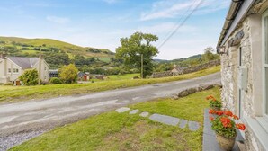 A rural road with houses and greenery in the background. - 2 Bed in Cwmystwyth (oc-p32779) (Cwmystwyth)