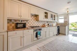 A kitchen with white cabinets, a microwave, a stove, and a dishwasher.